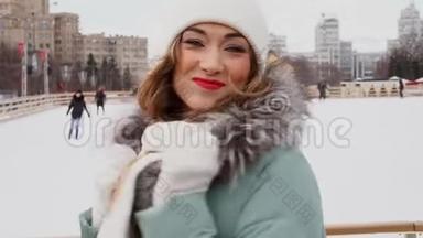 美丽可爱的中年女孩，卷发温<strong>暖</strong>的<strong>冬季</strong>夹克站在冰场背景镇广场。